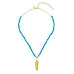 A 18ct gold-plated vermeil sterling silver necklace with a turquoise chain and a gold feather charm, complemented by a white zircon pave.