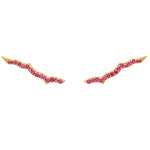 A pair of gold vermeil ear sliders with rubies set in them, designed to be worn as an ear accessory.