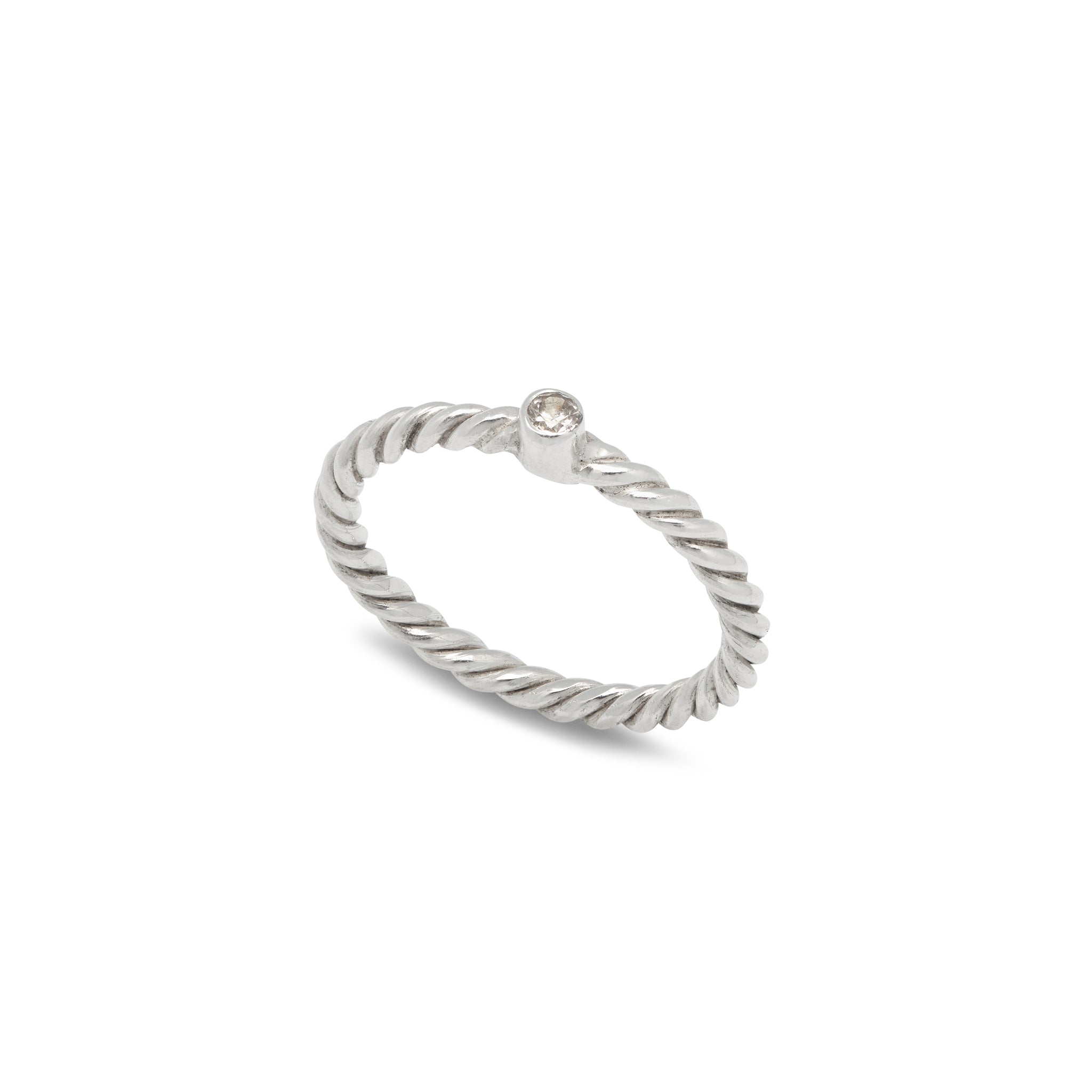 A sterling silver ring with a twisted motif and a natural white Zircon in the centre, intended for stacking with other rings.